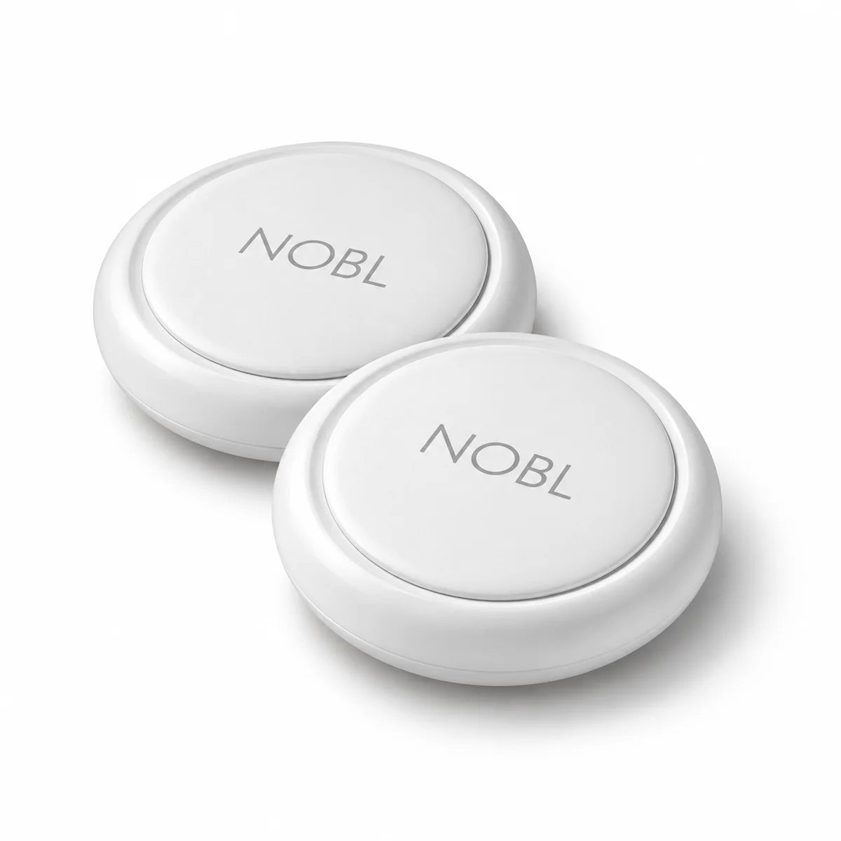 Two white round NOBL Air trackers