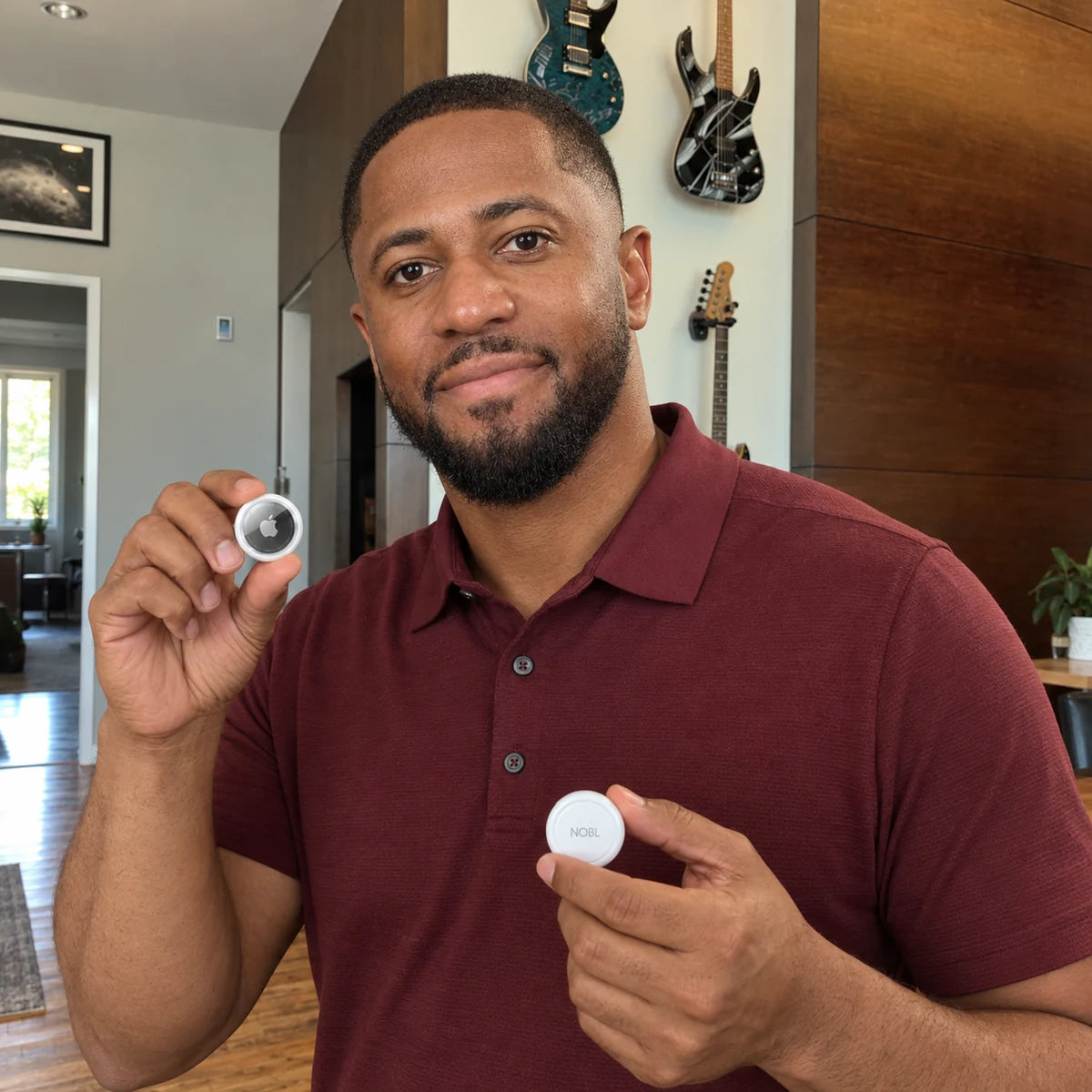 Man in a burgundy polo holding NOBL Air and Apple AirTag at home