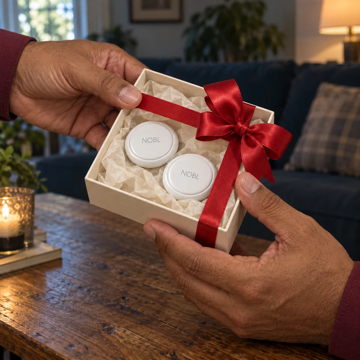 Two NOBL Air trackers in an unbranded gift box with a red ribbon
